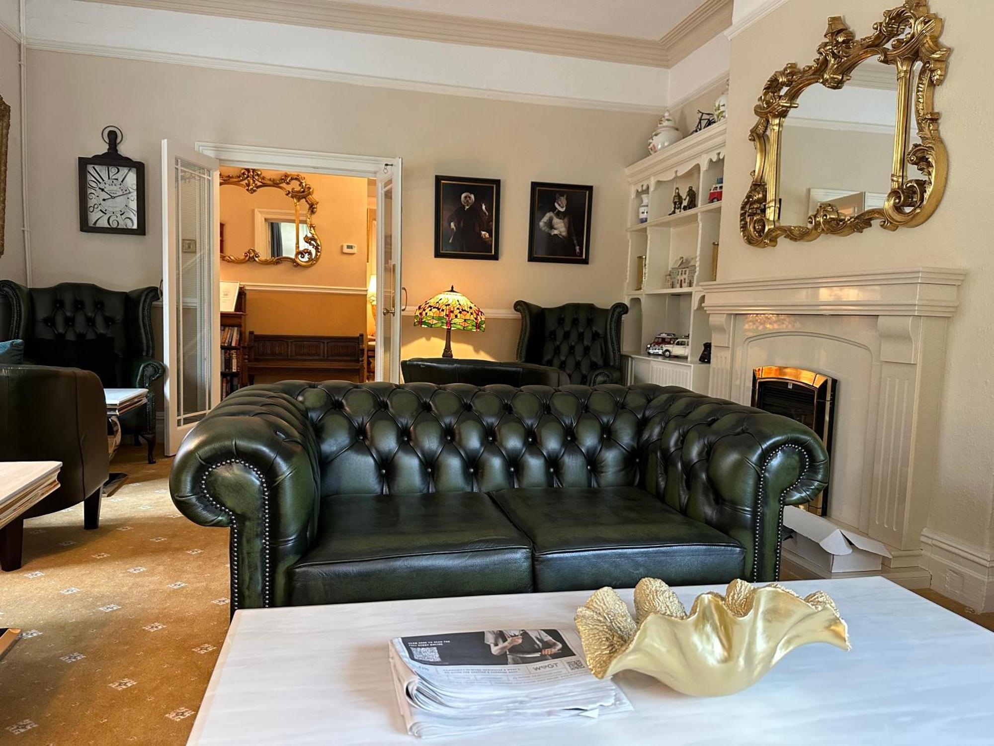 Chester House Guest House Bagian luar foto A green leather Chesterfield sofa